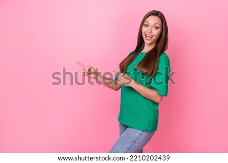 Photo of gorgeous good mood girl with straight hairdo dressed green t-shirt directing empty space isolated on pink color background