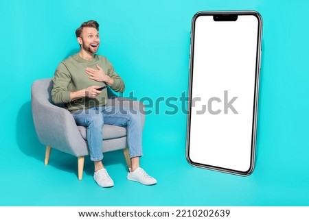 Full size photo of young guy watch tv wear shirt jeans footwear isolated on turquoise background