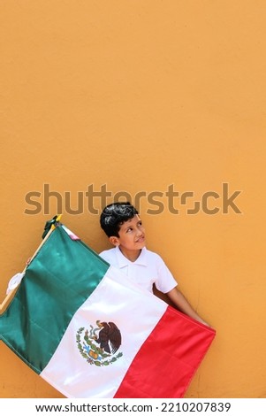 Latin Mexican boy of 8 years shows the flag of Mexico proud of his culture and tradition celebrates the national holidays of September 15 and Cinco de Mayo