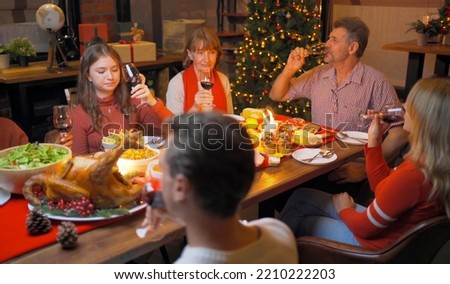 A group of multi ethnic. Portrait of Caucasian and African American black family, woman have a celebration dinner in party on Merry Christmas Eve Xmas on holiday at home or house. People lifestyle.
