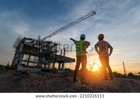 Engineer on a construction site passing by a construction site that blurs at sunset, an engineer inspects the construction of a water catchment tower