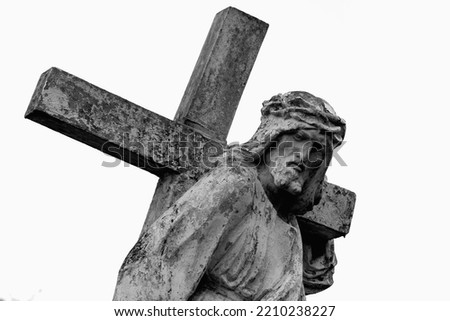 The road to Golgotha. Ancient statue of Jesus Christ with cross against white background.  Royalty-Free Stock Photo #2210238227