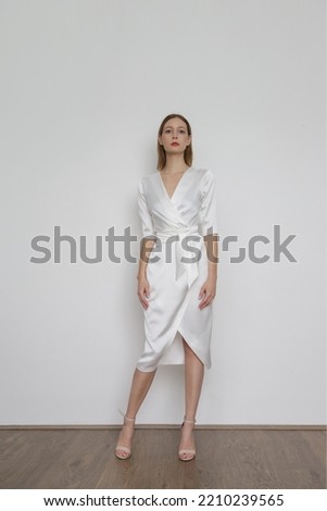 Serie of studio photos of attractive young woman wearing elegant white silk satin dress.	 Royalty-Free Stock Photo #2210239565
