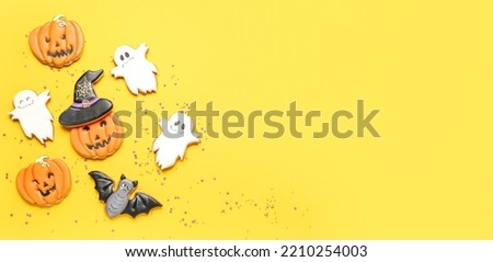 Tasty Halloween cookies on yellow background with space for text, top view