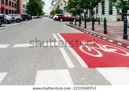 Red bike lane with painted white bicycle sign on city street