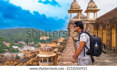 An Indian Male Solo Traveler enjoying the view of Jaigarh Fort from Amer Fort at Jaipur, Rajasthan, India. Royalty-Free Stock Photo #2210266921