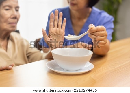 Senior asian woman bored with food. Royalty-Free Stock Photo #2210274455