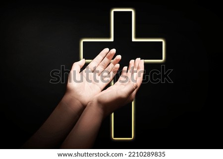 Christian cross and woman stretching hands towards light in darkness, closeup