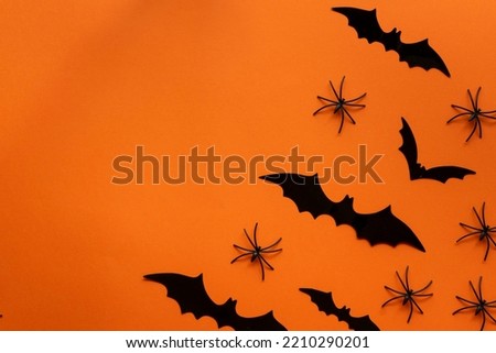 orange halloween background with bats and spiders on the right side leaving space on the left side