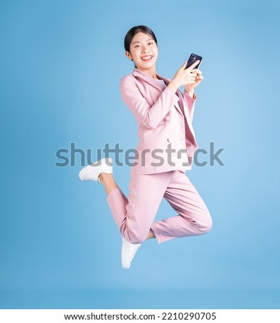 Young Asian business woman using smartphone on background Royalty-Free Stock Photo #2210290705