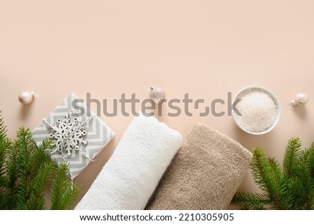 Winter body care and Christmas Spa concept with gift, cosmetic sea salt on beige background. View from above. Special offer for beauty services. Copy space. View from above.