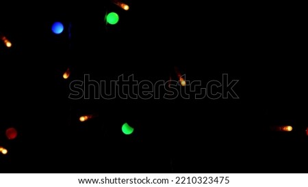 Multicolored garland lights on black background. New year or Christmas, versatile festive and magical backdrop. High quality photo