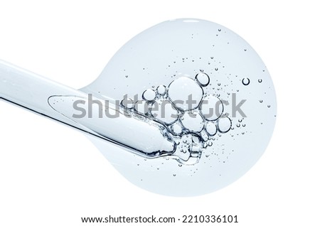 Pipette and a drop of cosmetic serum for the skin. Liquid body care product. Macrophotography. Isolated on a white background. Royalty-Free Stock Photo #2210336101