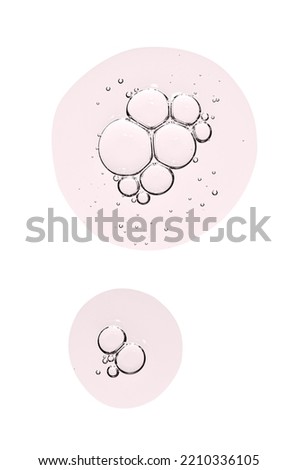 Drops of body serum or cosmetic oil with bubbles. Liquid skin care product. Isolated on a white background.