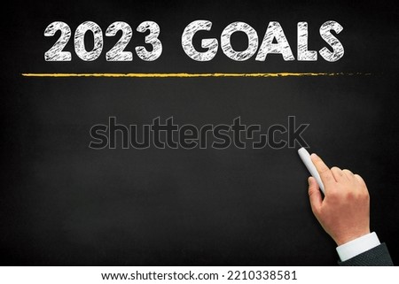 2023 Goals new year. A male hand writing new year golas on chalkboard