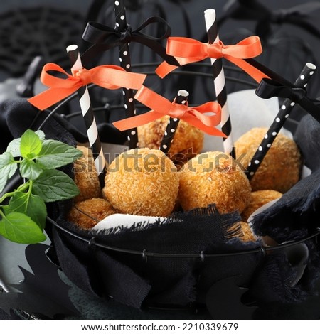 Pumpkin and purple sweet potato croquettes on a black basket.