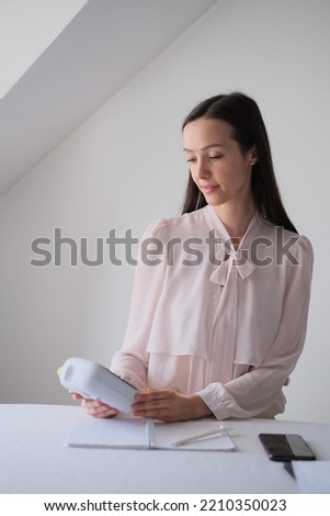 A female accountant works in the office. Business woman in stylish business clothes.