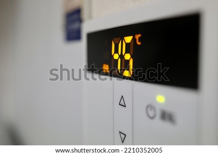 The temperature setting on this water heater is set at 45 degrees. Translation: operating. Priority. Royalty-Free Stock Photo #2210352005