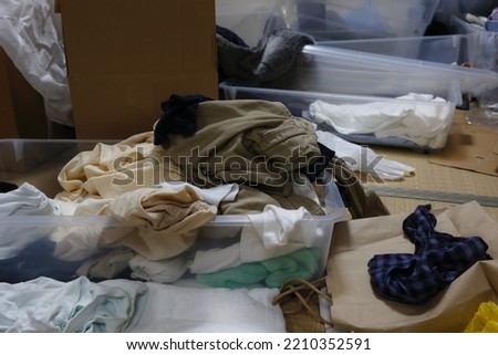 A dirty room with a lot of clothes and unused items. Royalty-Free Stock Photo #2210352591