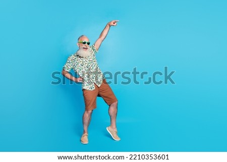 Full length photo of old excited grandfather dancing celebrating touch waist green glasses finger point new shopping mall isolated on blue color background
