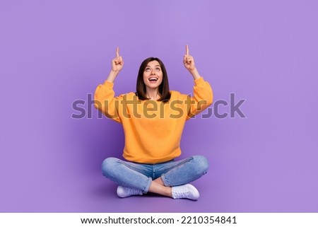 Full body size photo of charming adorable lady sitting crossed legs looking up fingers point mockup useful tips isolated on bright violet color background Royalty-Free Stock Photo #2210354841