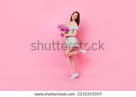 Full length photo of gorgeous lovely pretty positive lady raise leg hold flowers rejoice present gift isolated on pink color background