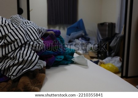 A dirty room with a lot of clothes and unused items. Royalty-Free Stock Photo #2210355841