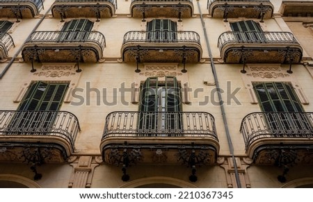 House facade of a magnificent house in the old town of Palma Mallorca. A travel photo of a beautiful street scenery in Spain with lots of windows, beige and red bricks