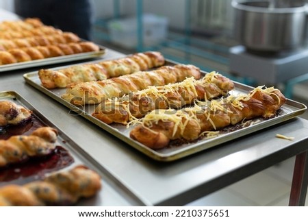 Cropped view of an appetizing dusted pie baked on the tray, they are baked on metal table.