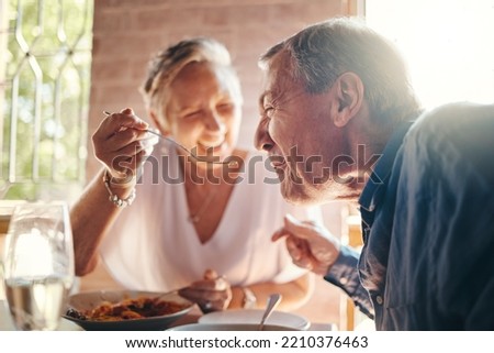 Couple, love and food with a senior man and woman on a date in a restaurant while eating on holiday. Travel, romance and dating with an elderly male and female pensioner enjoying a meal together Royalty-Free Stock Photo #2210376463