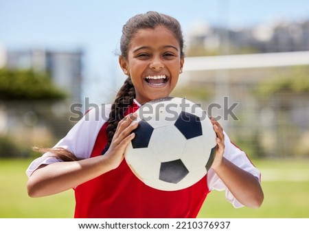 Soccer, sports and happy Indian girl athlete holding a sport ball on a school field. Portrait of fitness, football and exercise of a child smile excited about training, workout and game motivation Royalty-Free Stock Photo #2210376937