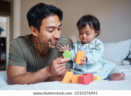 Baby, down syndrome and learning on a bed with child and father playing with educational blocks in a bedroom. Family, disability and kids bonding with asian parent, relax with creative activity Royalty-Free Stock Photo #2210376941