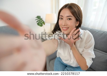 Young asian woman Making video call  on sofa in living room
