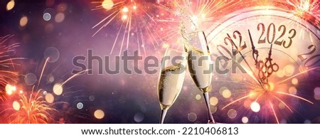 2023 New Year Celebration With Champagne  - Countdown To Midnight - Clock Fireworks And Flutes On Abstract Defocused Background Royalty-Free Stock Photo #2210406813