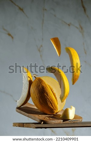 Creative photo of melon in flight, pieces of melon on a Light marbled background. photo of melon for the cover of a magazine or advertising, levitation of food, yellow, yellow fruit
