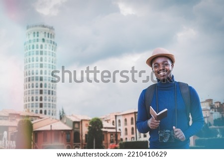 Portrait of African man backpack traveller with camera and vintage hat traveling in city.Handsome tourist man visiting Europe