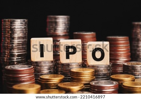 Business and finance concept. IPO word on wooden cube heap of coins.                          