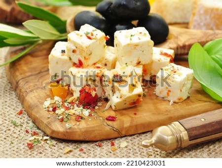 Feta cheese with herbs and spices on wooden background, closeup.