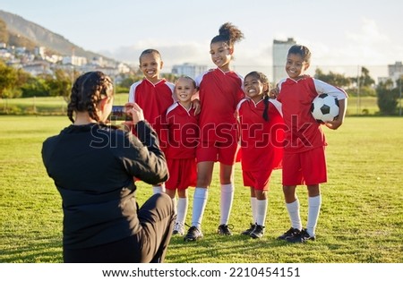 Soccer, photograph and sports coach with a girl team posing for a picture outdoor on a football field for fitness or training. Exercise, teamwork and picture with athlete kids or friends outside