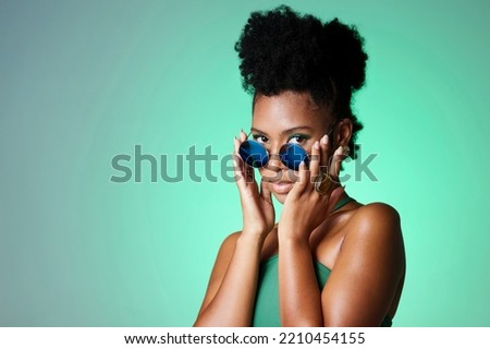 Portrait of trendy black woman in green background with sunglasses. Mockup for natural beauty, fashion and makeup in spring or summer. Black model in funky glasses, modern style in the studio