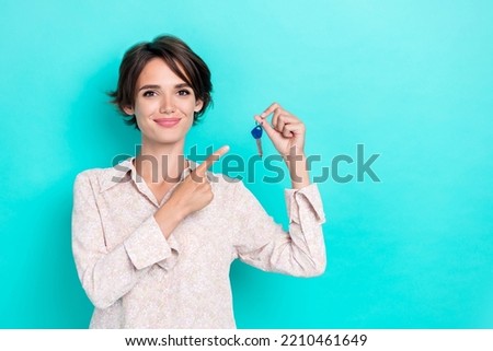Photo of pretty lady stylish outfit arm demonstrate key buy new flat move enjoy purchase empty space isolated on cyan color background