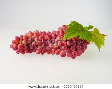Ripe red grapes. Pink bunch with leaves isolated on white. With trajectory cropping. Full depth of field.    