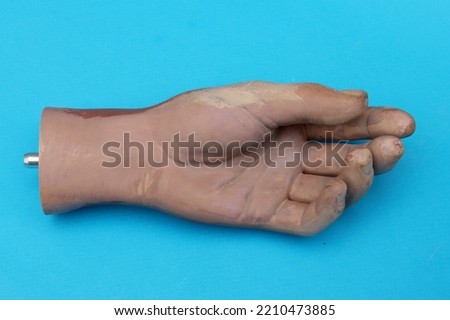 Part of the old artificial hand on blue background top view. Royalty-Free Stock Photo #2210473885