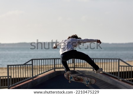 skateboarder jumping in a skatepark by the sea