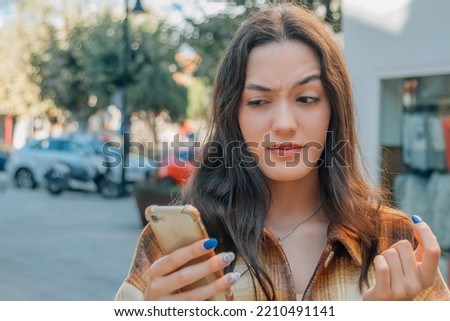 woman with mobile phone and expression of mistrust or doubt Royalty-Free Stock Photo #2210491141