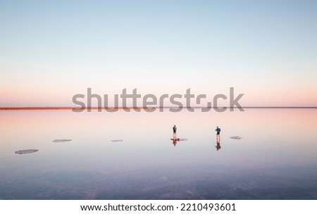 Photographers take photos on a salt lake at sunrise. Location place of Syvash Lake, Kherson Region, Ukraine, Europe. Fantastic photo wallpaper. Image of exotic places. Discover the beauty of earth.