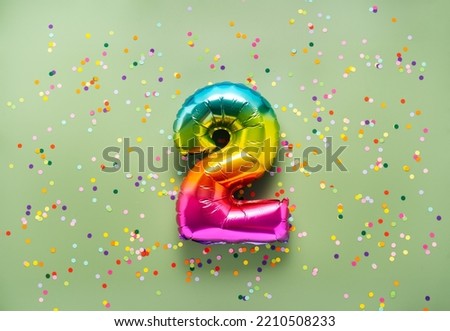 Colorful balloon number 2 on light green background. New Year of birthday concept