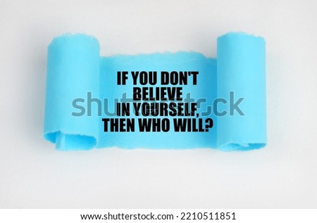 On a white surface, a blue scroll of paper with the inscription - IF YOU DON'T BELIEVE IN YOURSELF, THEN WHO WILL. Business concept. Royalty-Free Stock Photo #2210511851