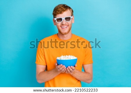 Photo of funky red hair guy watch film hold food wear orange t-shirt eyewear isolated on turquoise color background