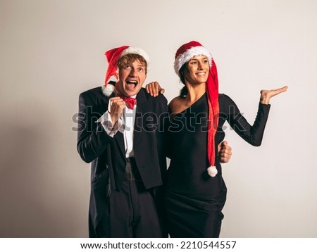 Smiling cheerful young Santa couple friends man woman. Christmas couple. Santa hats. 